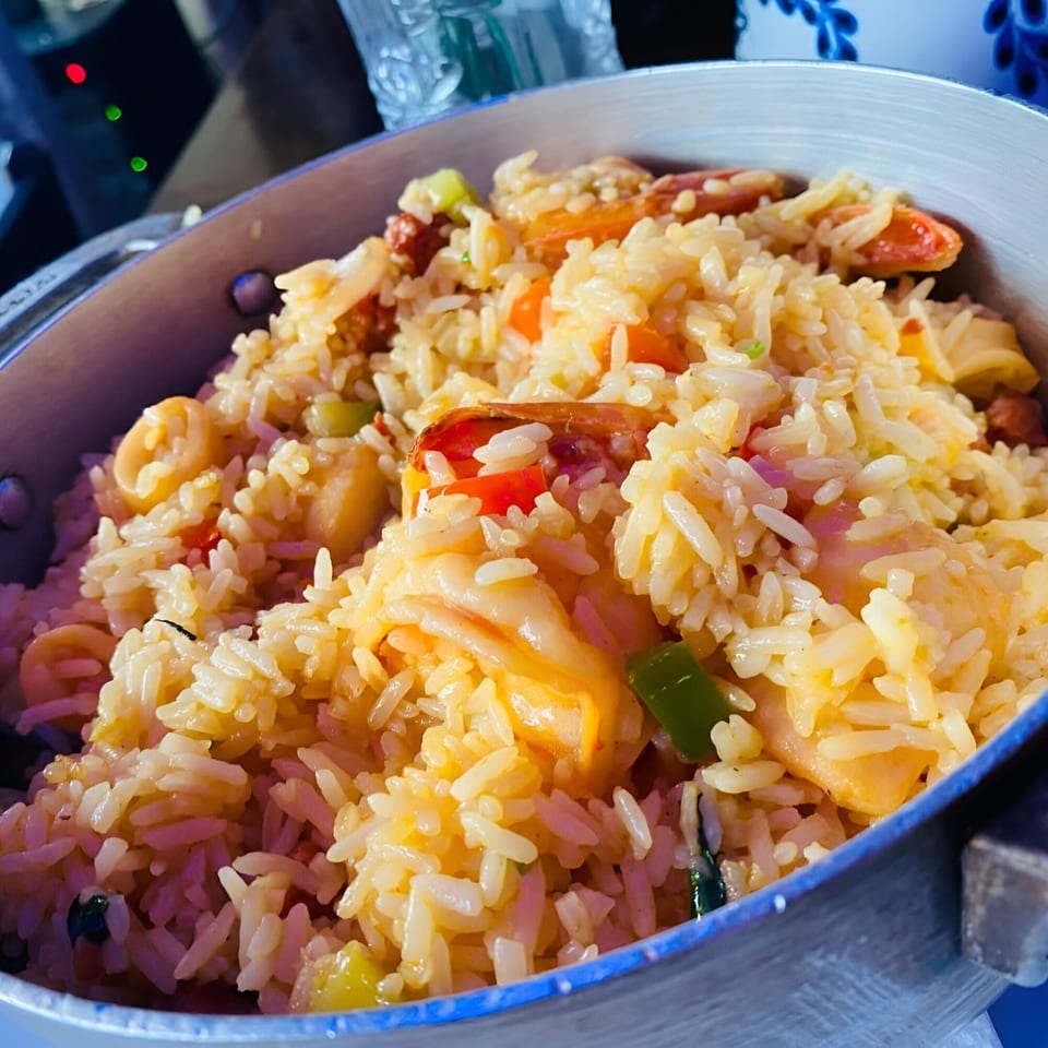 Close-up of Peruvian arroz con mariscos, a seafood rice dish with shrimp, squid, and vegetables.